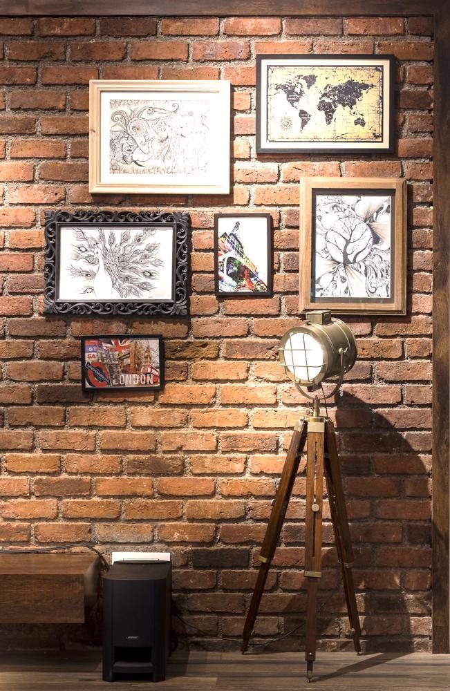 Exposed brick gallery wall with framed art in the Farmhouse Project, Badalapur