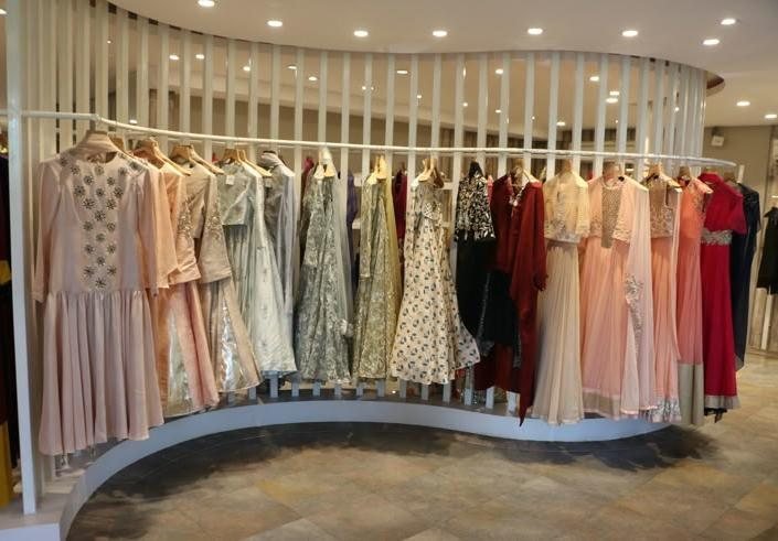 Reference image for the premium garments section: a curved white-slat garment rail against a marble floor