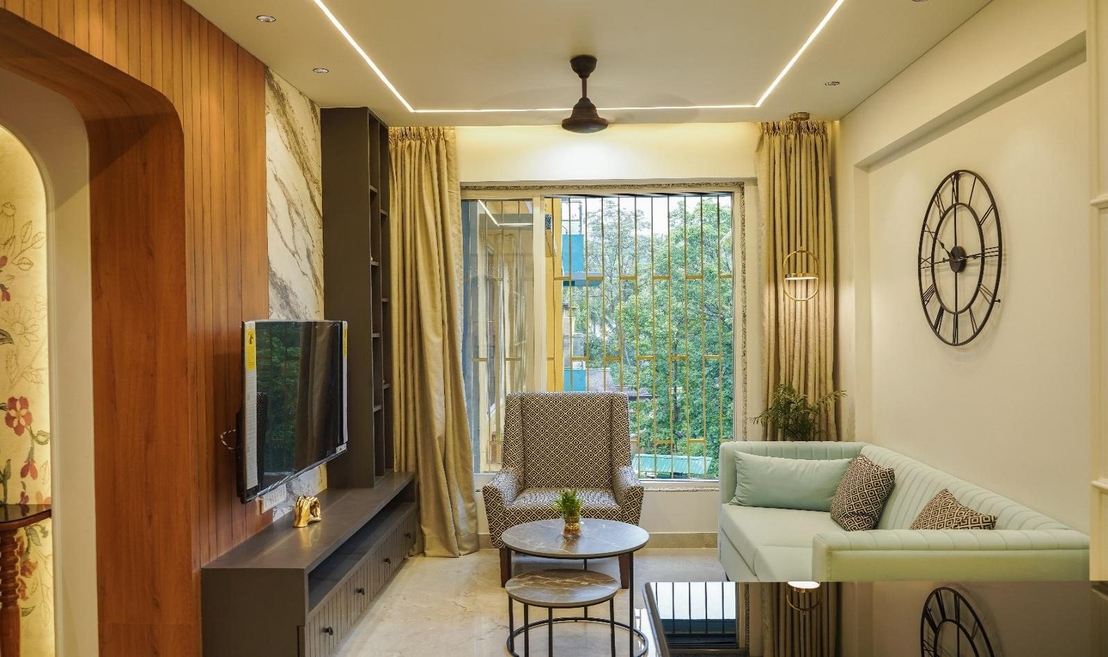 Karpe Residence living room with wood panelling and a statement wall clock