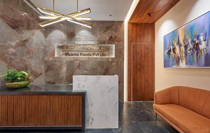 Sethwala Food Solutions reception desk in Malad with branded signage in marble and wood